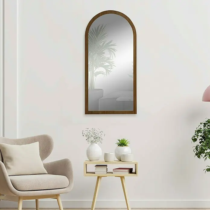 Espejo de pared Arco - 58 x 118 cm, Tabaco - Elegante decoración interior con un espejo alto con marco de madera que cuelga sobre una mesa auxiliar con decoración, contra una pared blanca.