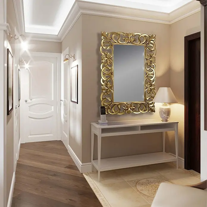Espejo de pared Berrocal - 88 x 128 cm, Oro betún - Interior elegante con un espejo dorado sobre una consola blanca, acentuado con una lámpara y un teléfono.