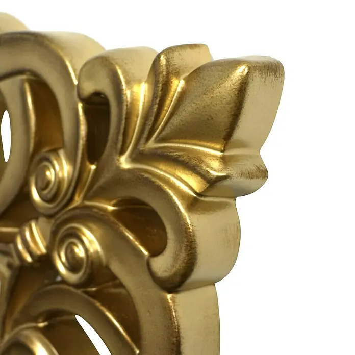 Espejo de pared Berrocal - 88 x 128 cm, Oro betún - Primer plano de un adorno decorativo dorado con intrincados remolinos y detalles artísticos. La superficie brillante resalta la elaboración artesanal.