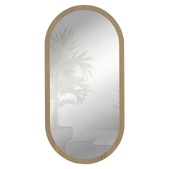 Espejo de pared Alba - 58 x 118 cm, Roble - Espejo ovalado con marco de madera clara que refleja una habitación con una palmera y muebles blancos. Elemento decorativo con estilo.