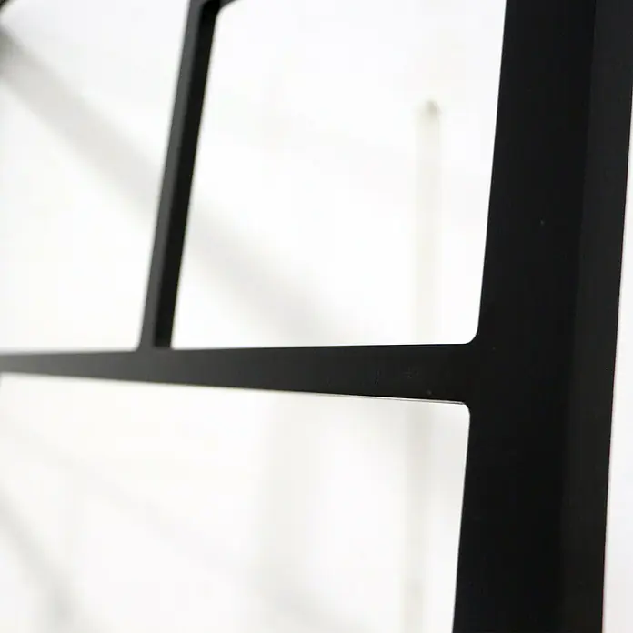 Espejo de pared Pop - 70 x 100 cm, Negro - Primer plano de una estantería de metal negro con líneas limpias y diseño minimalista sobre un fondo blanco.