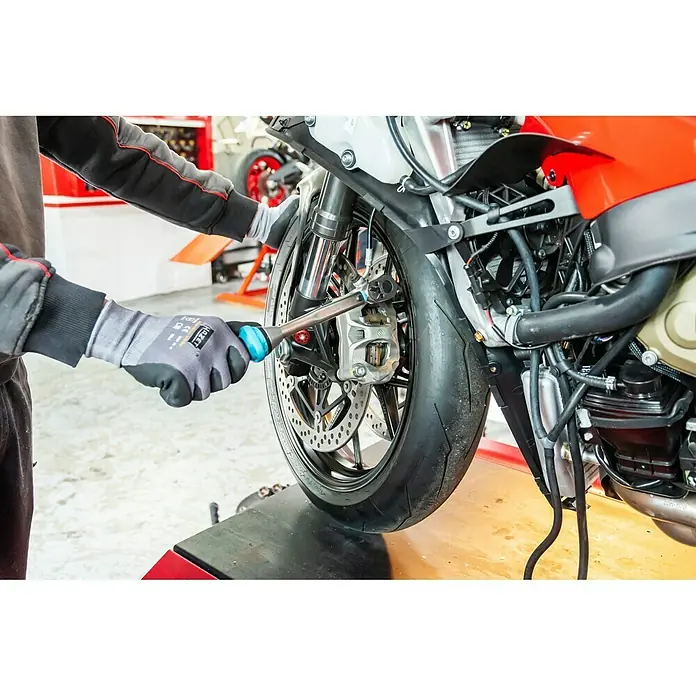 Hazet Drehmomentschlüssel 5120-3CT - ½″ Vierkant, 10 Nm - 60 Nm - Nahaufnahme eines Mechanikers, der an einem Motorrad arbeitet und einen Schraubenschlüssel benutzt, mit Fokus auf das Hazet-Werkzeug.