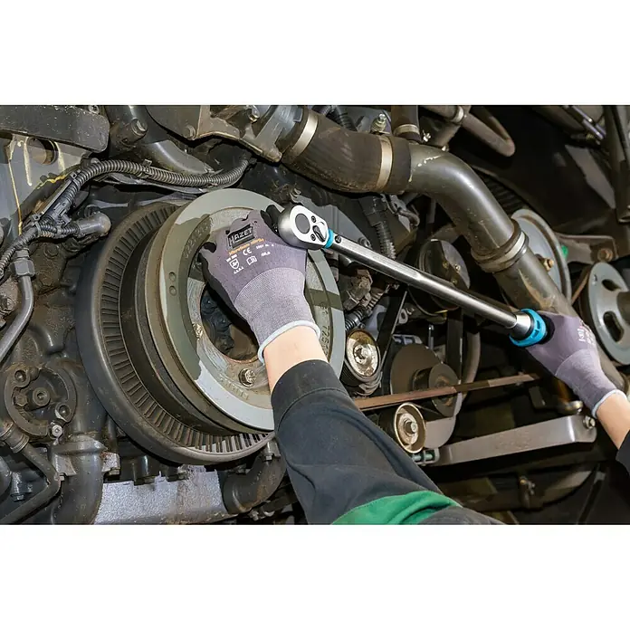 Hazet Drehmomentschlüssel 5123-3CT - ½″ Vierkant, 60 Nm - 320 Nm - Ein Mechaniker benutzt einen HAZET Drehmomentschlüssel an einem Motor. Die robuste Konstruktion und das präzise Anziehen zeichnen das Werkzeug aus.