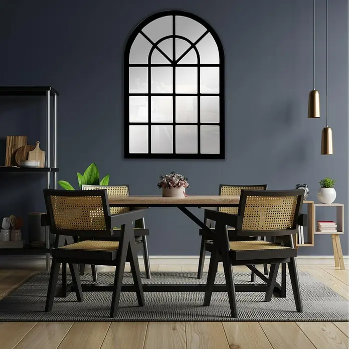 Espejo de pared Catania - 70 x 100 cm, Negro - Elegante comedor con un gran espejo arqueado con marco de ventana que cuelga sobre una mesa de madera con cuatro sillas.