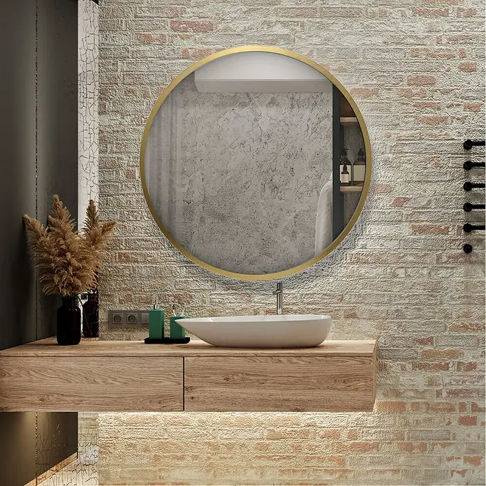 Espejo de pared Circular - Diámetro: 55 cm, Oro betún - Un baño con un espejo redondo sobre un tocador de madera. La pared de azulejos aporta calidez a la habitación. Diseño de interiores minimalista.