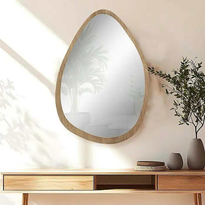 Espejo de pared Esfera - 64 x 89 cm, Roble - Un espejo de pared de forma irregular con marco de madera cuelga sobre una mesa de madera con objetos decorativos y plantas en jarrones.
