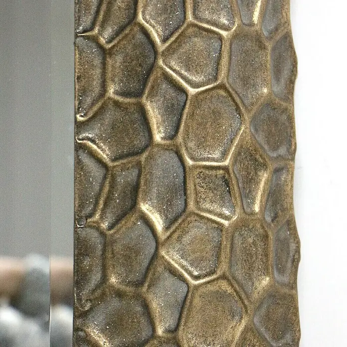Espejo de pared Malasia - 70 x 100 cm, Oro - Primer plano de un espejo decorativo con marco en tono bronce con patrón celular. Un toque elegante para cualquier habitación.