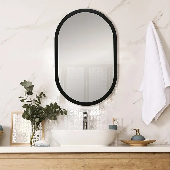 Espejo de pared Ovalado - 45 x 70 cm, Negro liso - Espejo ovalado con marco negro sobre un lavabo moderno. Perfecto para un toque de estilo en el baño.