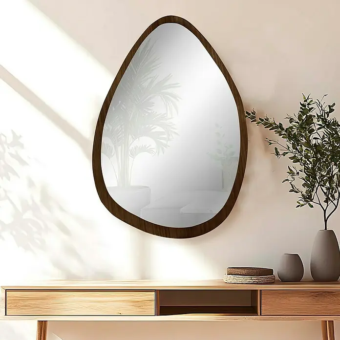 Espejo de pared Esfera - 64 x 89 cm, Tabaco - Un espejo elegante de forma irregular con un marco de madera cuelga en la pared, acentuando el ambiente moderno de la habitación.