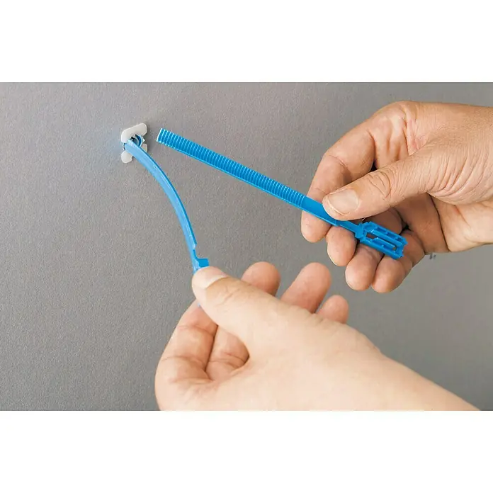 Knauf Gipsplatten Klappdübel Hartmut - Länge Dübel: 190 mm, Länge Schraube: 60 mm - Blauer Kabelbinder wird an einer Wand befestigt. Der Kabelbinder ist ein nützliches Werkzeug für viele Anwendungen.