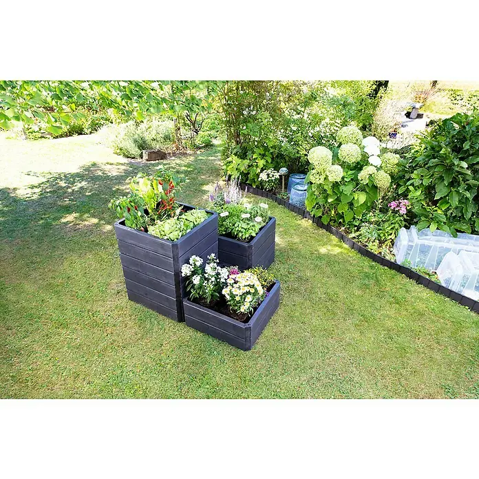 Garantia Hochbeet Ergo Quadro S - 60 x 60 x 25 cm, Kunststoff, Anthrazit, Holzoptik - Das Bild zeigt stilvolle, dunkle Pflanzkästen aus Holz mit Gemüse und Blumen auf einem grünen Rasen im Garten.