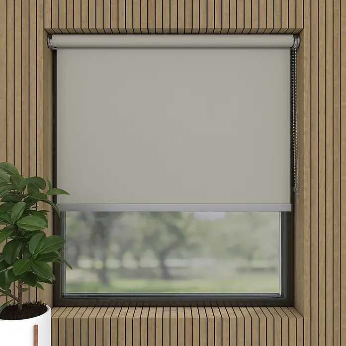 Verdunkelungsrollo Luxus - B x H: 230 x 190 cm, Hellgrau - Blick auf eine graue Rollo, die vor einem Fenster mit Blick auf einen grünen Garten hängt und für Privatsphäre und gedämpftes Licht sorgt.