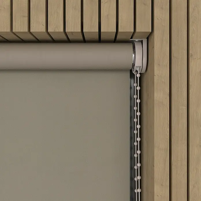 Verdunkelungsrollo - B x H: 130 x 190 cm, Twill, 100 % Polyester - Detailaufnahme einer beigen Rollgardine mit Kettenzug vor einer hölzernen Wand.