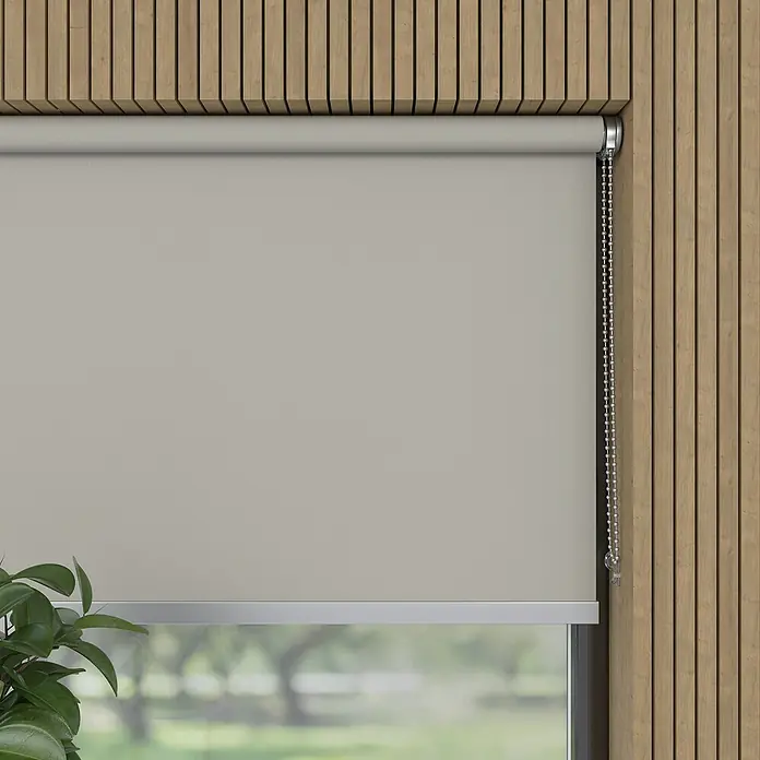 Verdunkelungsrollo Luxus - B x H: 230 x 190 cm, Hellgrau - Beige Rollo vor einem Fenster mit Blick ins Grüne, montiert an einer Holzwand. Ideal für Wohnräume, um Licht zu regulieren.