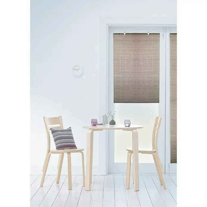 Estor enrollable Basic - An x Al: 100 x 180 cm, Chocolate - Interior de una habitación luminosa con mesa redonda de madera, dos sillas con cojines y ventana con persianas.