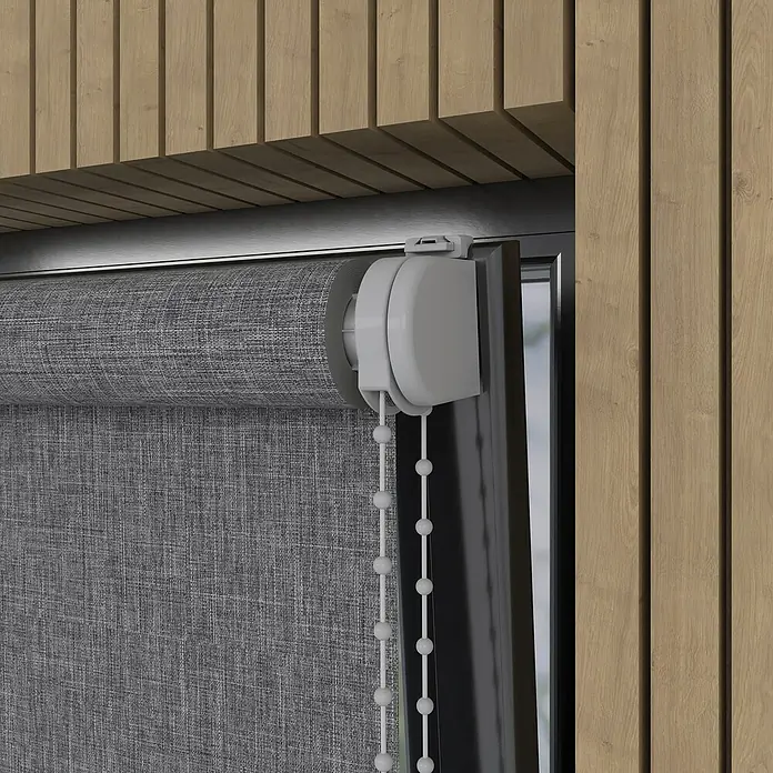 Verdunkelungsrollo Struktur - B x H: 115 x 190 cm, Dunkelgrau - Nahaufnahme einer grauen Rollo-Jalousie mit weißen Bedienelementen vor einem Hintergrund aus Holzpaneelen.