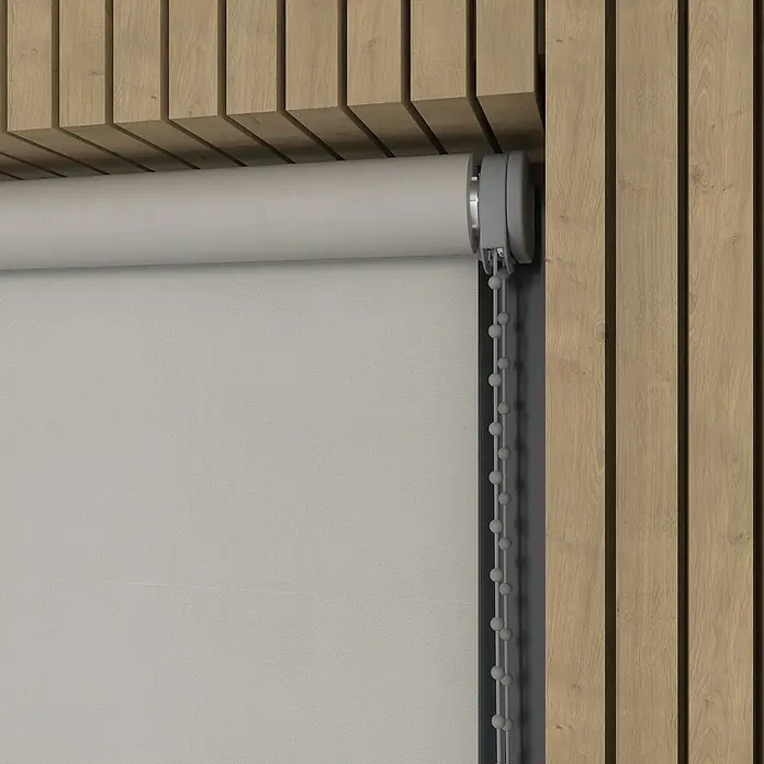 Verdunkelungsrollo - B x H: 220 x 190 cm, Hellgrau, 100 % Polyester - Nahaufnahme einer grauen Rollgardine mit Kettenzug vor einer Wand mit Holzpaneelen, die eine moderne und minimalistische Ästhetik erzeugt.