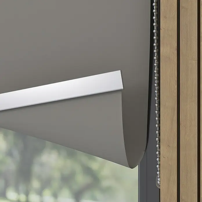 Verdunkelungsrollo Luxus - B x H: 200 x 190 cm, Grau - Nahaufnahme einer grauen Rollmarkise mit einem silbernen Kettenzug an einem Fenster mit Holzrahmen und Blick nach draußen.