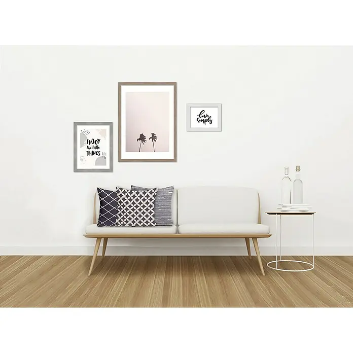 Accent Holzrahmen Oslo - 50 x 70 cm, Weiß - Wanddeko-Set mit drei gerahmten Bildern über einem Sofa, das eine moderne und stilvolle Atmosphäre schafft.