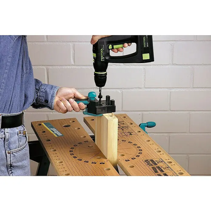 Wolfcraft Guía para espigas - Plástico, Topes integrados - Primer plano de una escena de carpintería con un taladro Festool y un asistente de espigas Wolfcraft para taladrar con precisión.