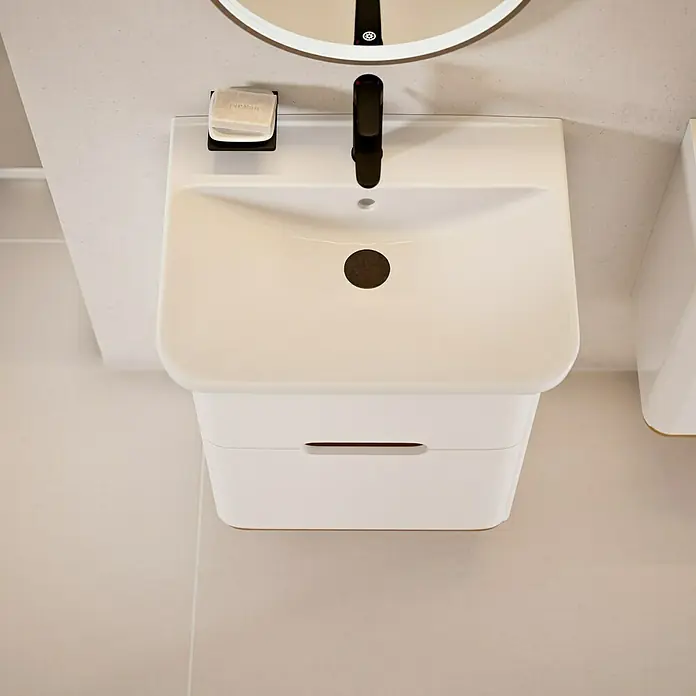 VitrA Sento Badmöbel-Set Sento - 63 cm, Weiß, 2 Schubladen - Nahaufnahme eines modernen weißen Waschbeckens mit schwarzem Wasserhahn und Seife, montiert auf einer weißen Wand.