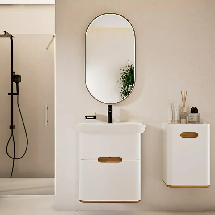 VitrA Sento Badmöbel-Set Sento - 63 cm, Weiß, 2 Schubladen - Badezimmer-Interieur mit einem weißen Waschtischunterschrank mit Schubladen, einem ovalen Spiegel und einer weißen Wandablage.