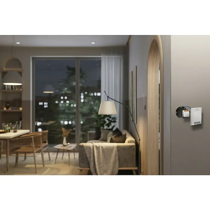 Osram Smart+ Schalter 1CH - Weiß, Innen - Ein intelligenter Lichtschalter an einer grauen Wand in einem modernen Wohnzimmer. Er bietet einfache Steuerung und Komfort für Ihr Zuhause.