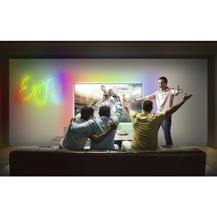 Osram Smart+ LED-Band Flex - Länge: 300 cm, Lichtfarbe: RGB, 15 W, 220 V - 240 V - Freunde jubeln vor einem Fernseher mit Umgebungsbeleuchtung, die das Seherlebnis verbessert und eine lebendige Atmosphäre schafft.