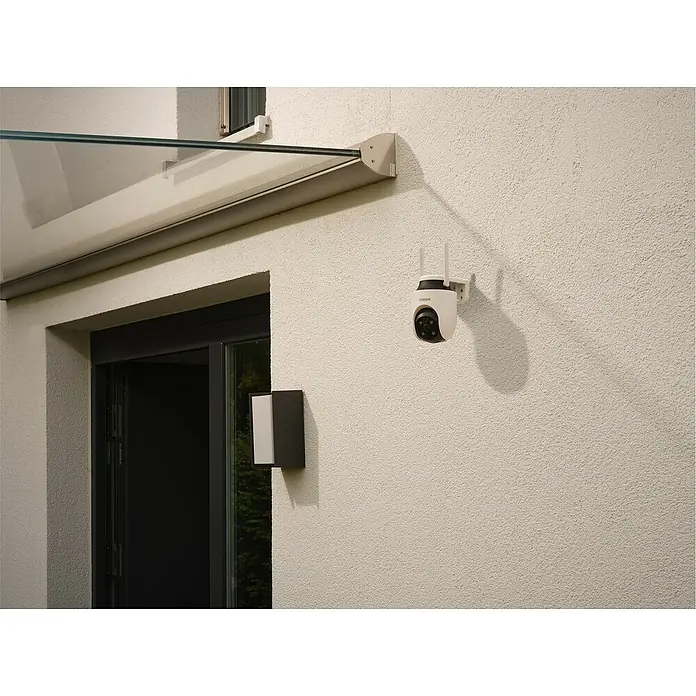 Osram Smart+ Überwachungskamera Outdoor 360 - Passend für: Alarmsystem, Smart Home System - Eine Osram Überwachungskamera ist an einer weißen Wand neben einer Tür montiert, die Sicherheit und Überwachung bietet.