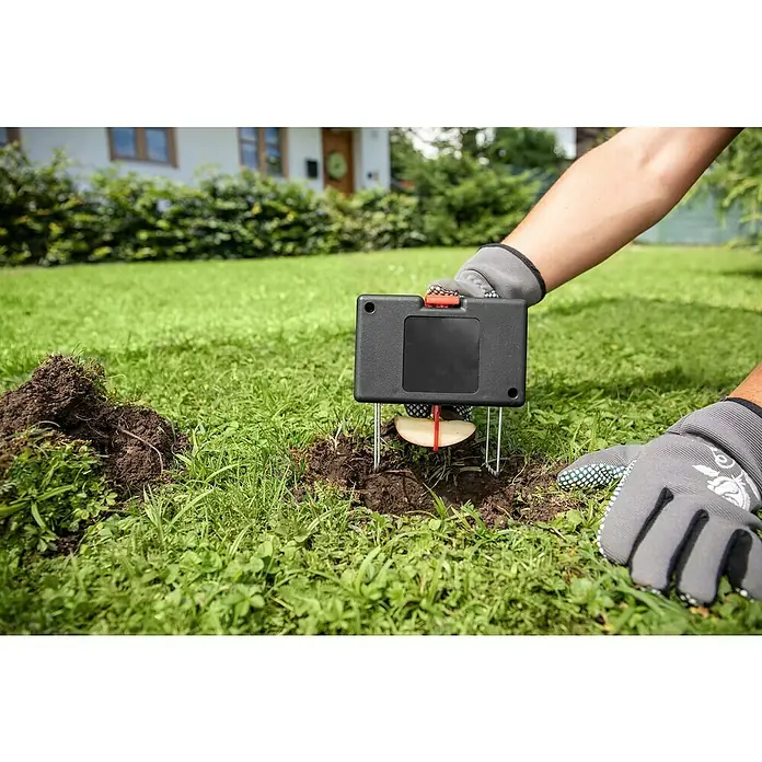 Windhager Wühlmausfalle Track & Catch - Unterirdische Falle, Kunststoff - Eine Maulwurffalle wird mit einem Apfelstück bestückt und in den Gartenboden eingesetzt, um Maulwürfe zu fangen.