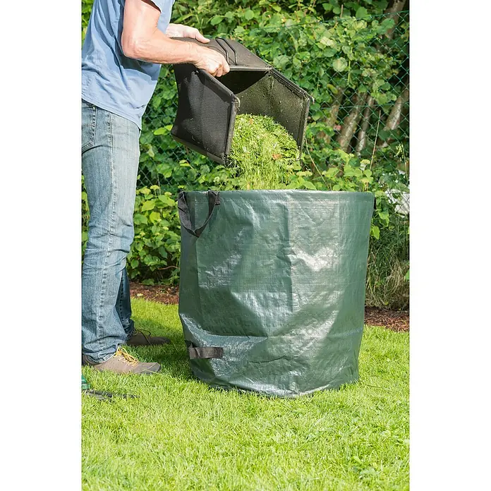 Windhager Gartenabfallsack - 80 l - Eine Person leert einen Grasfangkorb in einen grünen Gartensack auf einem Rasen.