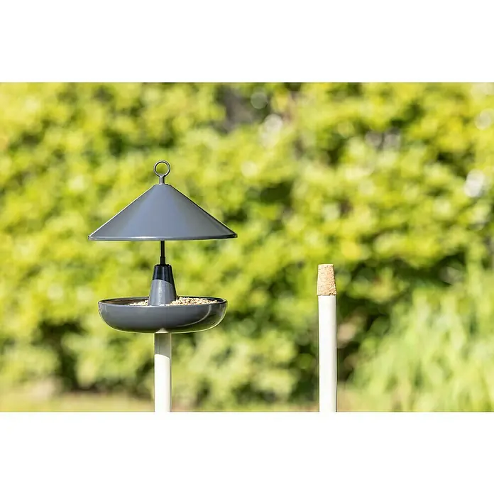 Windhager Vogelhaus Korny - Metall, Anthrazit - Vogelhaus mit Vogelfutter auf einem Stab mit einem grünen Hintergrund.