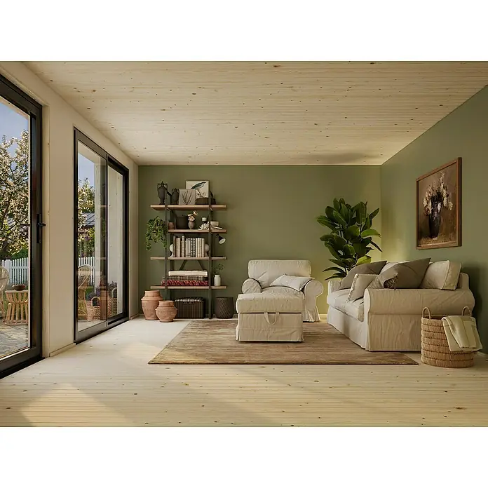 Palmako Gartenhaus Rebekka Nordic Plus - Außenmaß inkl. Dachüberstand (B x T): 562 x 446 cm, Holz, Natur unbehandelt - Helle, einladende Wohnzimmeransicht mit bequemen Möbeln, Bücherregal und Blick durch die Glastüren auf den Garten.