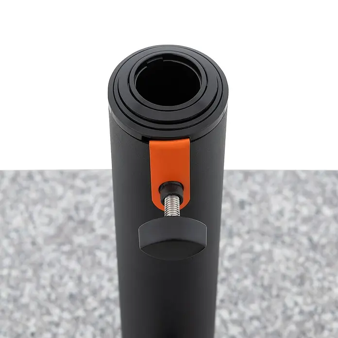 Doppler Granitschirmständer MyZone - 70,5 kg, Passend für: Doppler MyZone Sonnenschirme - Nahaufnahme einer gerollten Yogamatte in Schwarz mit orangefarbener Halterung und Drehknopf auf grauem Untergrund.