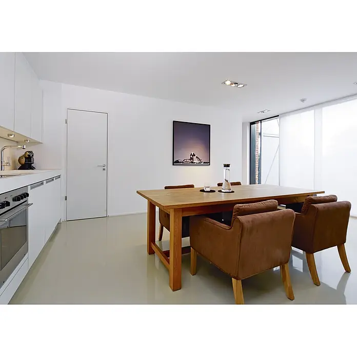 Atlantis Vliestapete Glattvlies Basic XXL Mega - Weiß, Uni, 50 x 0,75 m - Esszimmer mit einem Holztisch und braunen Armlehnstühlen, minimalistisch und modern eingerichtet. Helles Interieur mit Kunstwerk an der Wand.