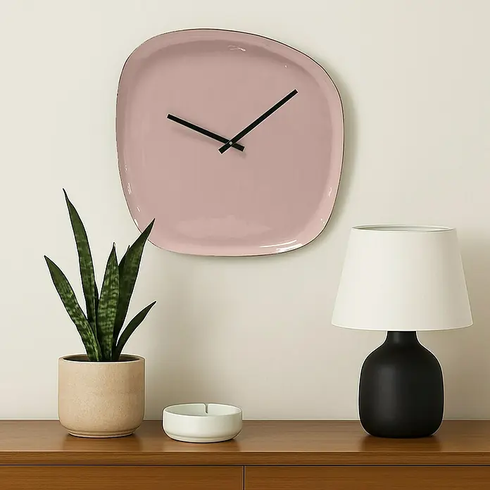 Wanduhr Tomo - Durchmesser: 42 cm, Mokka - Eine Nahaufnahme einer rosa Wanduhr, einer Topfpflanze und einer Lampe auf einem Holzschrank.