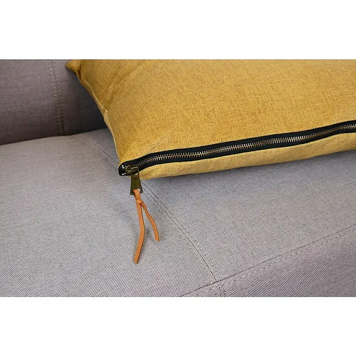 Kissen Finn - Gelb, 45 x 45 cm, 100 % Polyester - Nahaufnahme eines gelben Kissens mit Reißverschluss und Lederband auf einem grauen Sofa.
