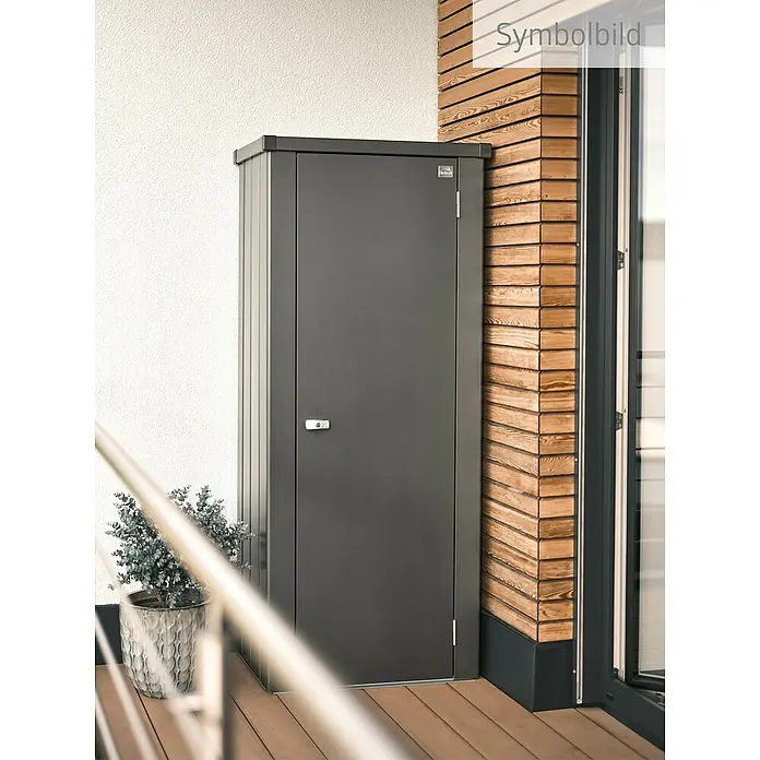 Biohort Julia Geräteschrank - Außenbreite inkl. Dachüberstand: 78 cm, Außentiefe inkl. Dachüberstand: 57 cm, Stahl, Dunkelgrau Metallic - Abbildung eines anthrazitfarbenen Geräteschranks aus Metall, der sich ideal für die Aufbewahrung von Gartengeräten eignet. Er steht auf einer Terrasse neben einer Holzwand.