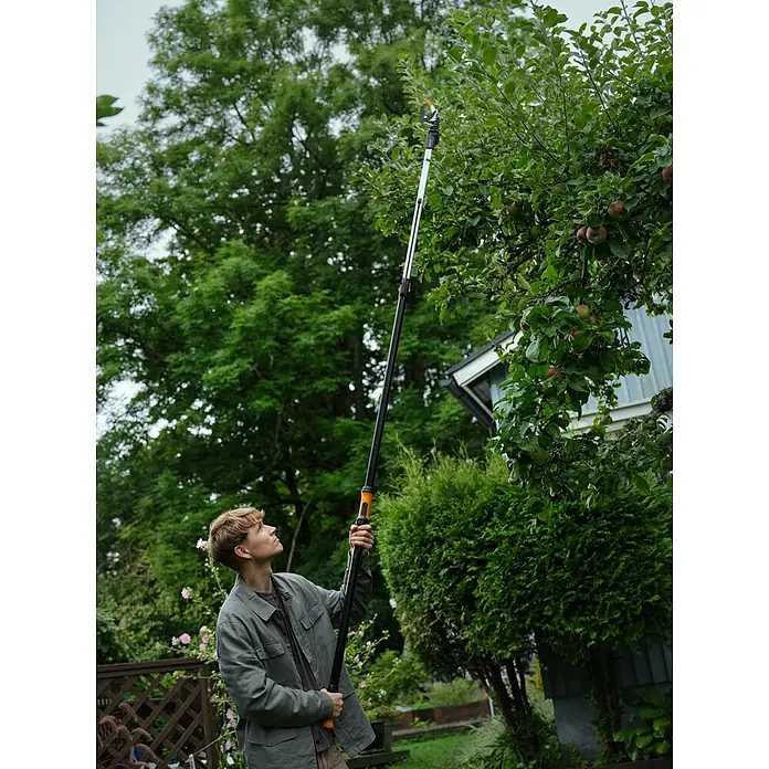 Fiskars X-series Teleskop-Schneidgiraffe DualAction UPX96 - Länge: 243,9 cm, Kunststoff - Mann mit einer Baumsäge, um Äste von einem Baum zu schneiden. Eine praktische Gartenschere für die Baumpflege und den Obstbaumschnitt.