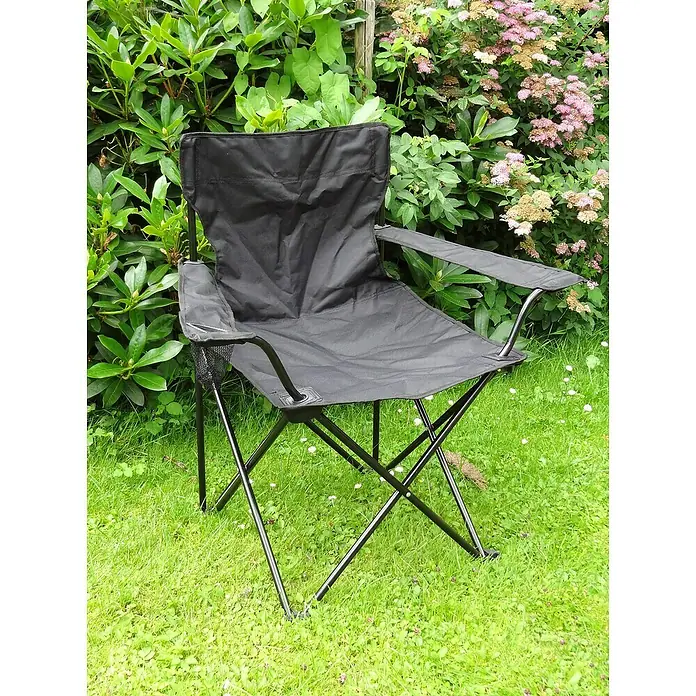 Westerholt Campingstuhl - Stahl, Textilene, Schwarz, B x T x H: 54 x 73 x 95 cm - Schwarzer Faltstuhl aus Stoff mit Stahlrahmen, ideal für Camping, Garten oder den Strand, steht auf einer Rasenfläche vor Büschen.