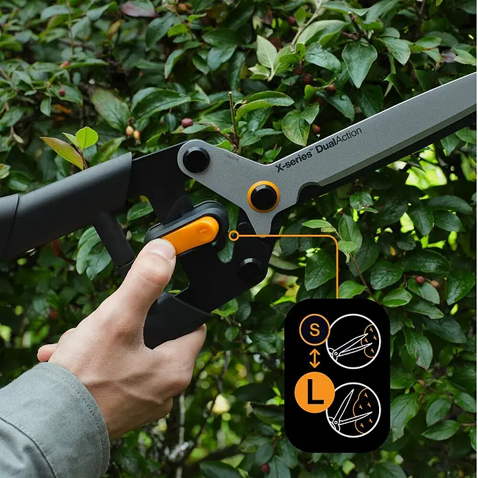 Fiskars X-series Hand-Heckenschere DualAction HSX96 - Länge: 62,7 cm, orange, schwarz, metallic - Die Fiskars X-series DualAction Heckenschere im Einsatz, mit Detailaufnahme des Verstellmechanismus für verschiedene Schnittstärken.