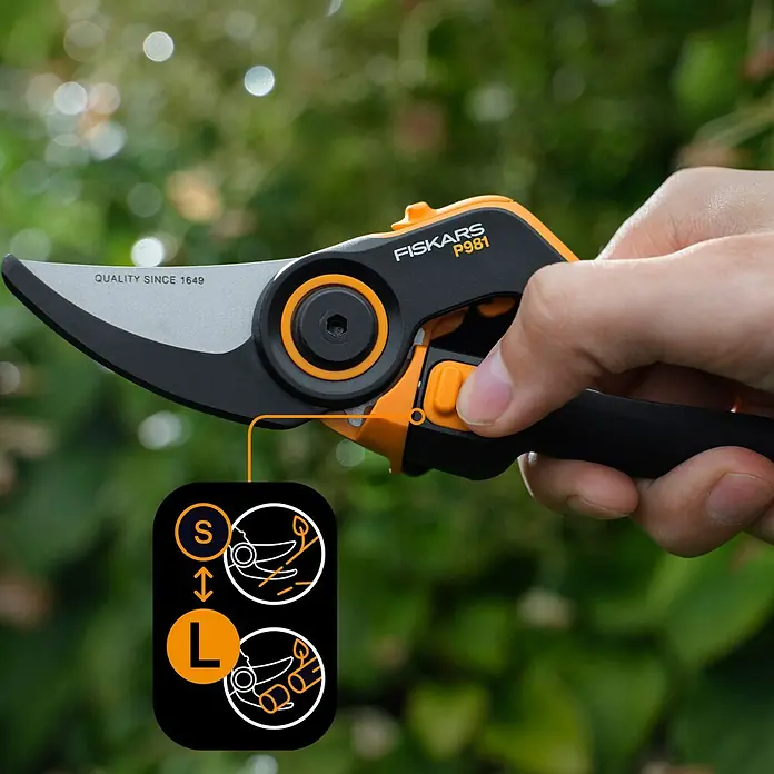 Fiskars X-series Gartenschere DualAction P981 - Bypass, Max. Aststärke: 26 mm - Eine Nahaufnahme einer Fiskars P981 Gartenschere, die in einer Hand gehalten wird, mit Fokus auf die Größenanpassungsfunktion.
