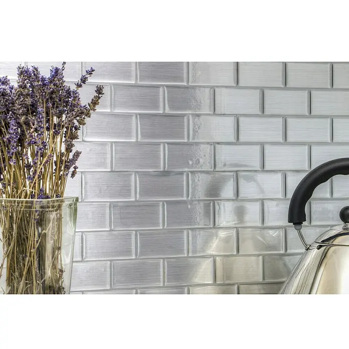 Selbstklebemosaik SVM 24002 - 24,8 x 25,5 cm, Silber, Glänzend - Nahaufnahme von silberfarbenen Metrofliesen an der Wand, ergänzt durch Lavendel in einer Vase und einen eleganten Teekessel.