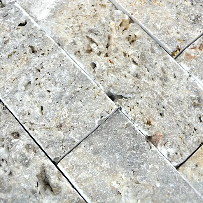Mosaikfliese Brick Splitface X3D 42781 - 30,5 x 29 cm, Silber, Matt - Nahaufnahme von strukturierten, grauen Travertin-Wandfliesen, die ein natürliches und elegantes Design für die Innenraumgestaltung bieten.