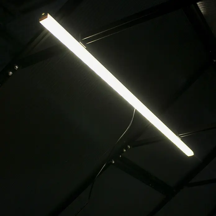 LED-Deckenleuchte - 5 W, L x B x H: 2,1 x 100 x 2,3 cm - Nahaufnahme einer Neonröhre, die an einer dunklen Decke befestigt ist und für helle Beleuchtung sorgt.