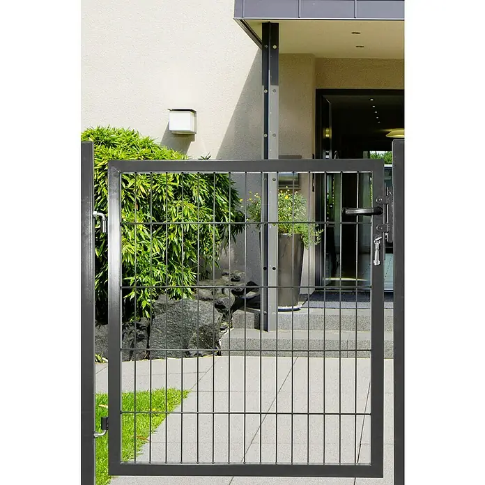 Peddy Shield Zauntor DSM1 x 0,8 m, Anthrazit, Stahl - Ein graues Gartentor aus Metallgitter vor einem Haus mit Pflanzen. Das Tor ist geschlossen und hat einen Griff mit Schloss.