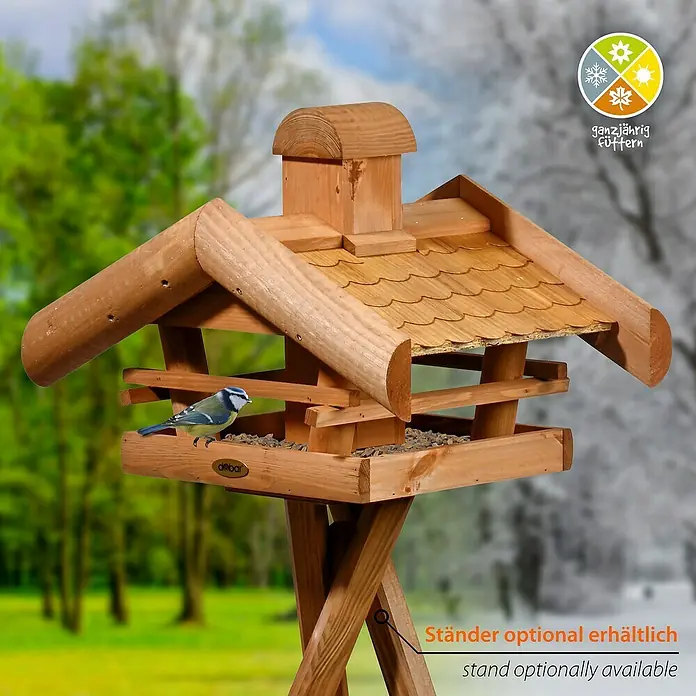 Dobar Vogelhaus Blätterfall - Holz, Braun, ca. 48 x 39 x 35 cm - Bild eines Holz-Vogelhauses mit einem kleinen blauen Vogel, umgeben von Bäumen und einem Hinweis auf optionale Ständer.