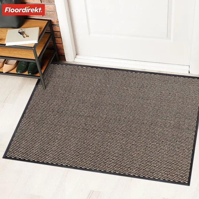 Fußmatte Sky Novo - Ocker, 120 x 80 cm, Material Nutzschicht: 100 % Polypropylen - Eine Fußmatte mit dezentem Muster vor einer weißen Tür, neben einem Schuhregal. Ideal für den Eingangsbereich.