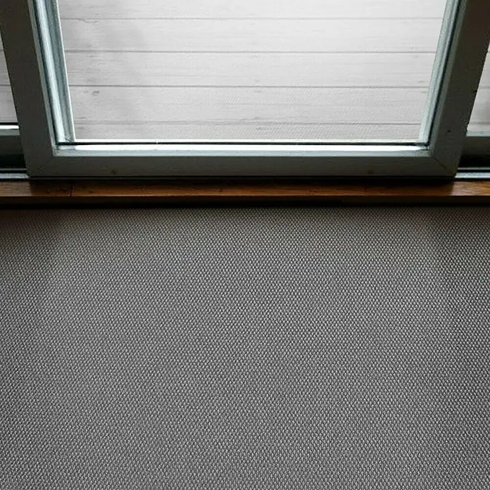 Schmutzfangmatte Hong Kong - Grau, 1.100 x 200 cm, 100 % Polypropylen - Blick durch ein Fenster auf eine helle, holzartige Oberfläche, darunter eine graue, textile Wand.