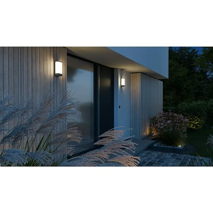 Steinel Außenwandleuchte L 14 - 9,5 x 7 x 27 cm, Anthrazit, IP44, Ohne Bewegungsmelder - Elegante Außenansicht eines Hauses mit modernen Wandleuchten, die ein warmes Licht auf die Fassade und die Bepflanzung werfen.